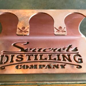 a metal sign that says secret distilling company