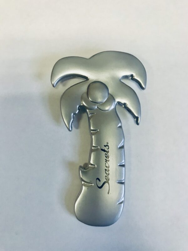 a metal brooch with a palm tree on it