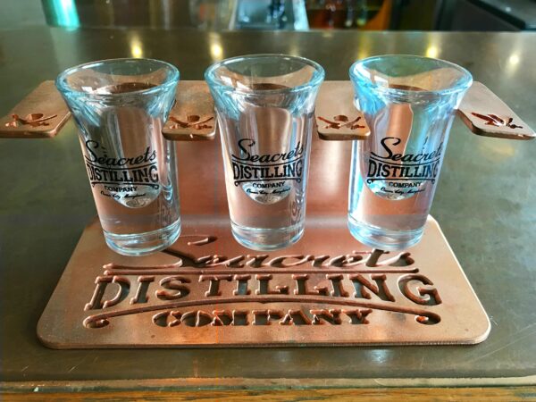 a set of four shot glasses sitting on top of a metal tray