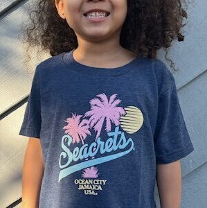 a young girl smiles while standing on a deck
