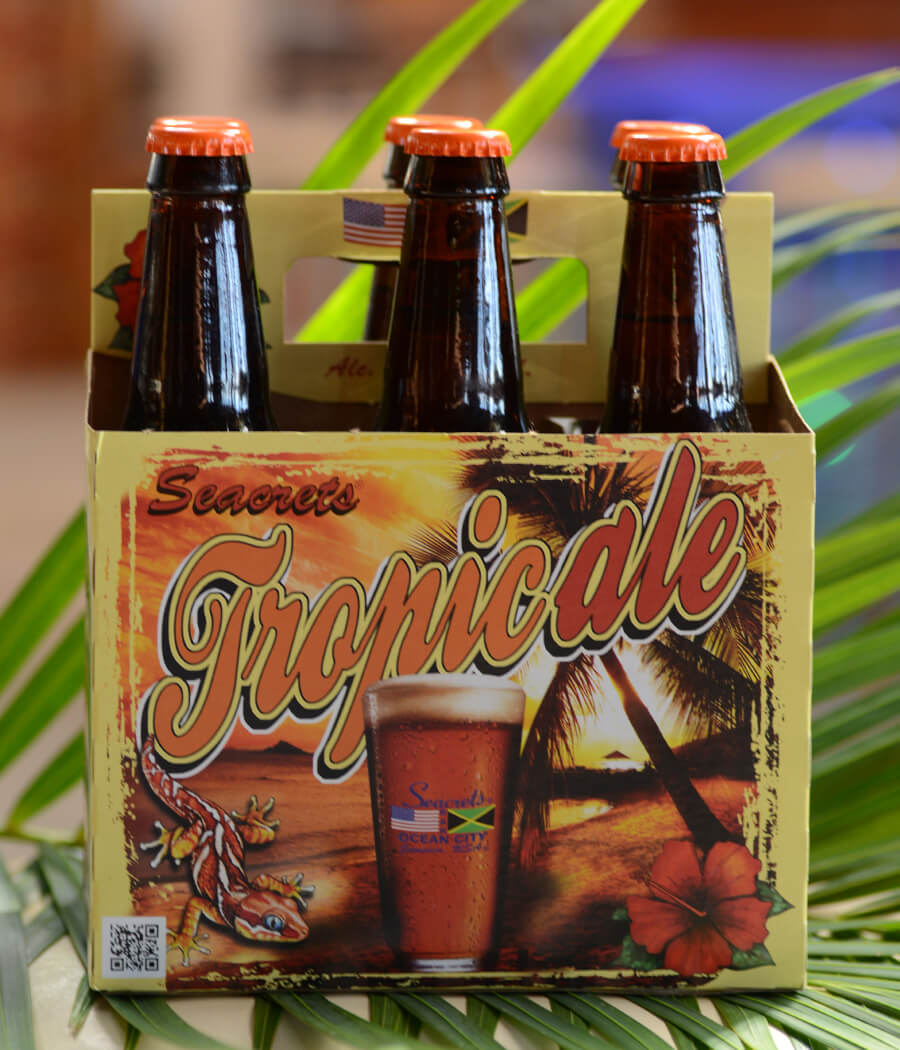 a group of four bottles of beer sitting on top of a palm tree