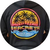 a man wearing a black hoodie with a sunset and palm trees on it