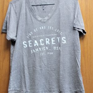 a gray shirt hanging on a wooden wall