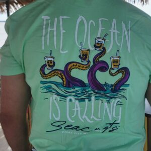 a man wearing a t - shirt that says the ocean is calling