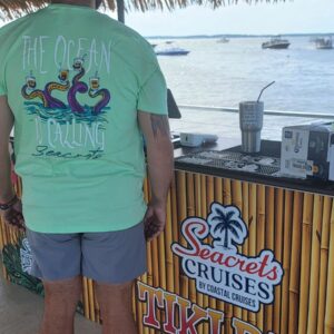 a man standing in front of a bar next to the ocean