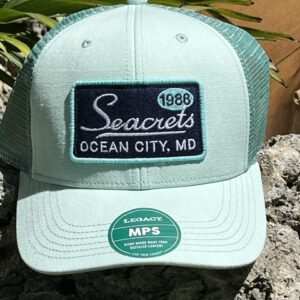 a green and white hat sitting on top of a rock