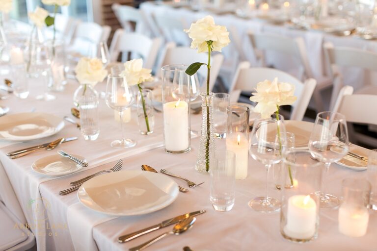 a table set for a formal dinner with candles and flowers