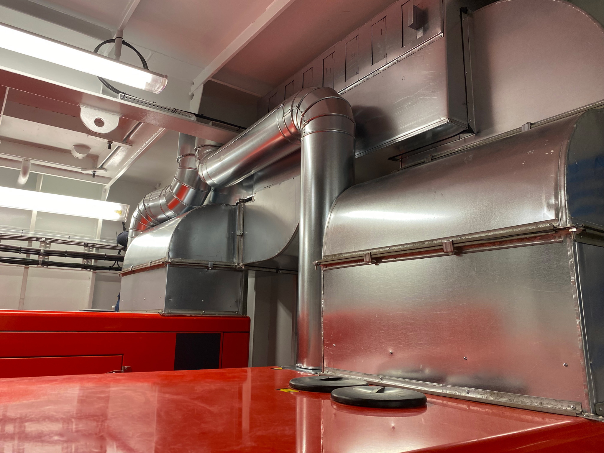a red table in a room with metal pipes