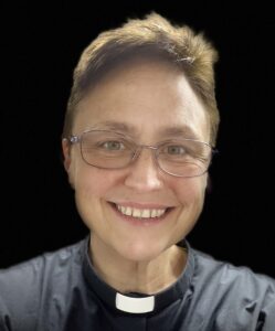 a woman wearing glasses and a priest's outfit