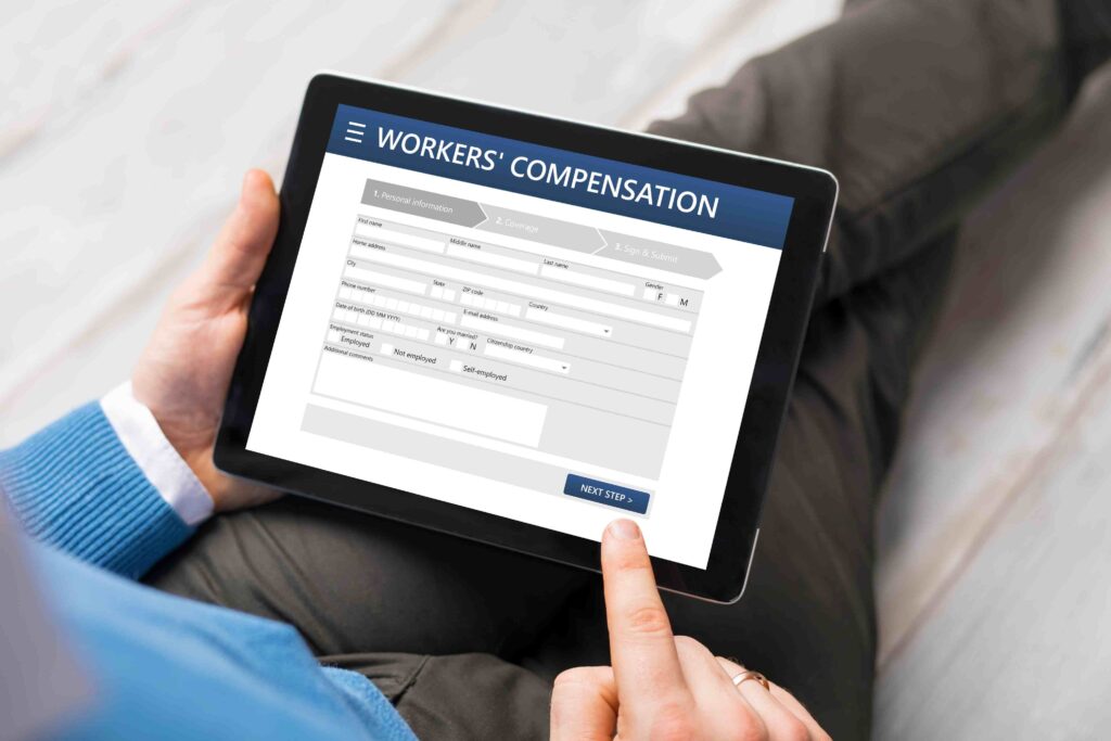 a person holding a tablet with a work's compension on it