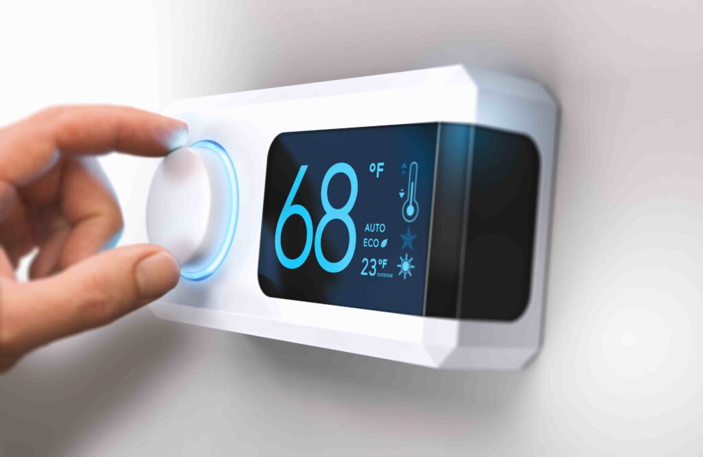 a person turning thermostaer on with their hand