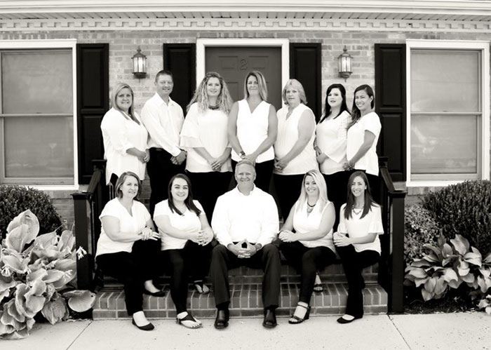 Staples & Associates team posing outside office door