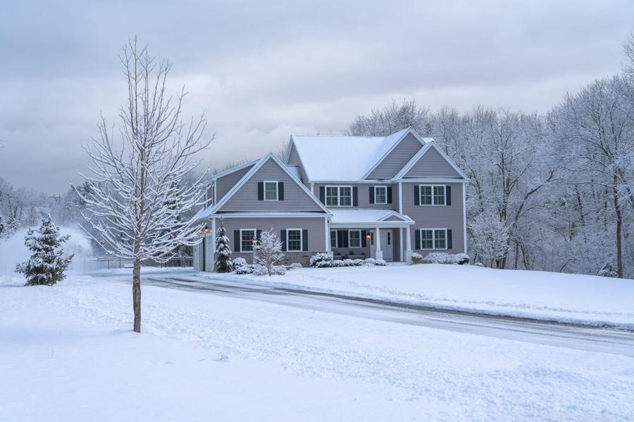 a house in the middle of a snow covered street