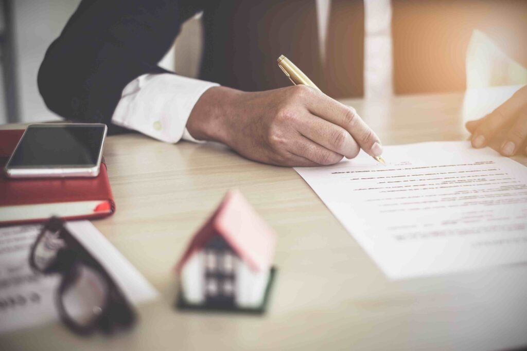 a person signing a document with a pen
