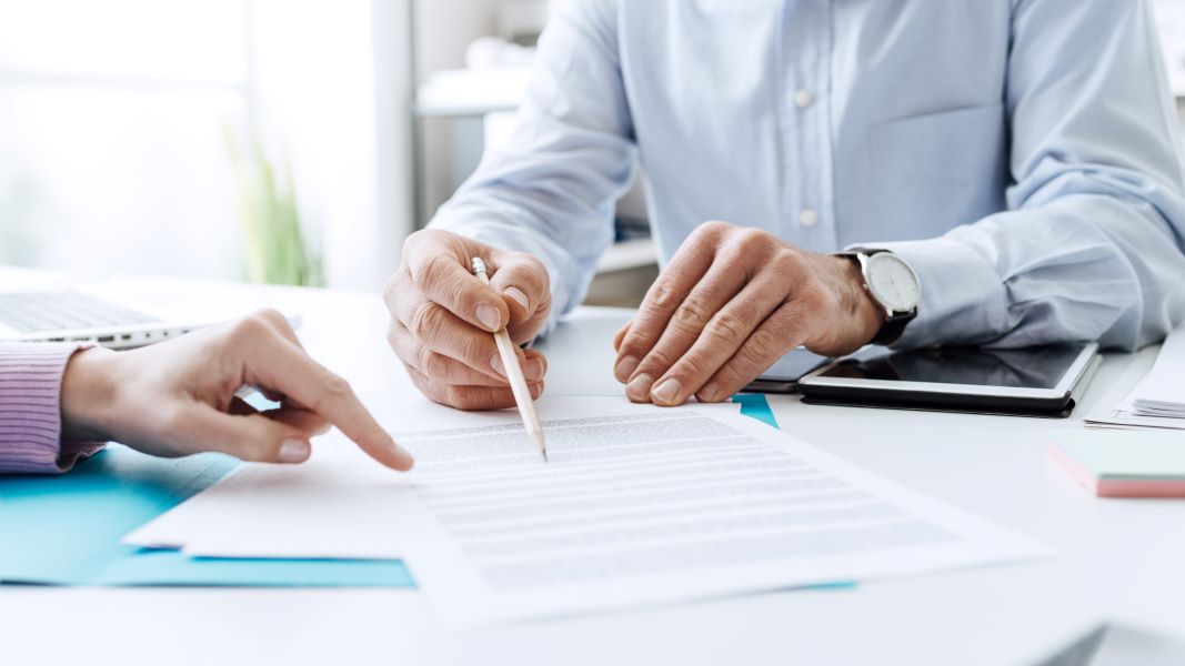 two people sitting at a table signing papers