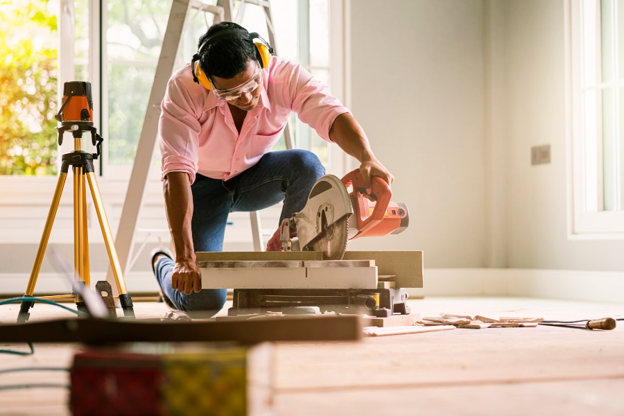 a woman in pink shirt using a circular saw