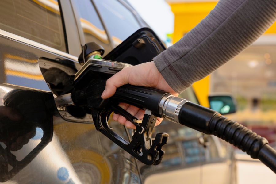 a person pumping gas into a car at a gas station
