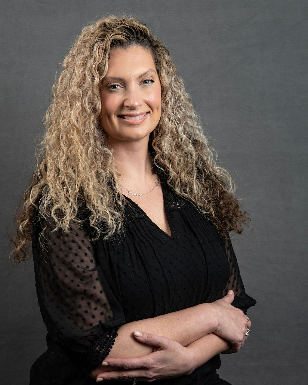 a woman with long curly hair is posing for a picture