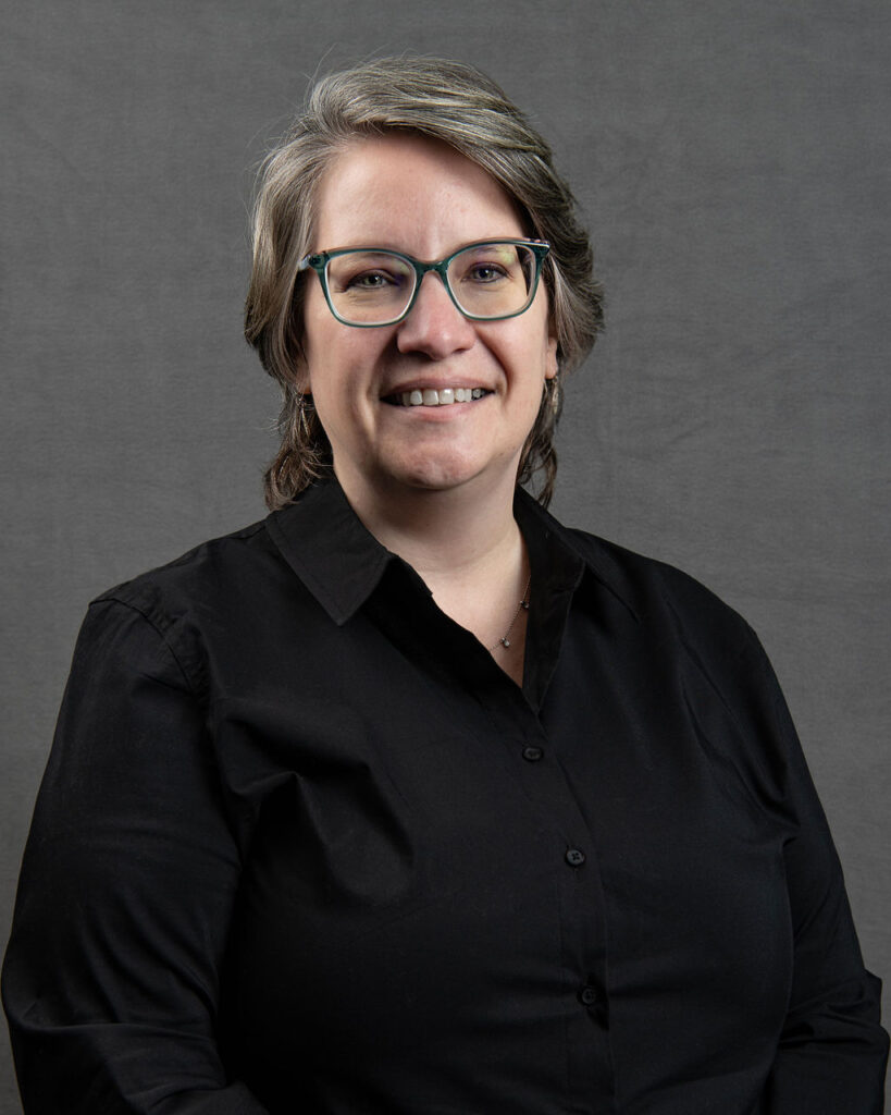 a woman with glasses is smiling for the camera