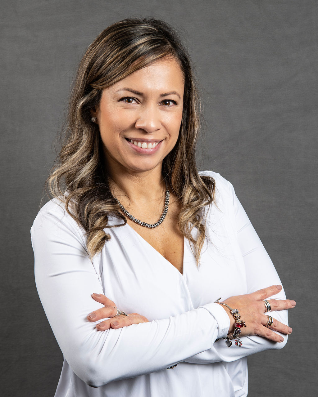 a woman with her arms crossed posing for a photo