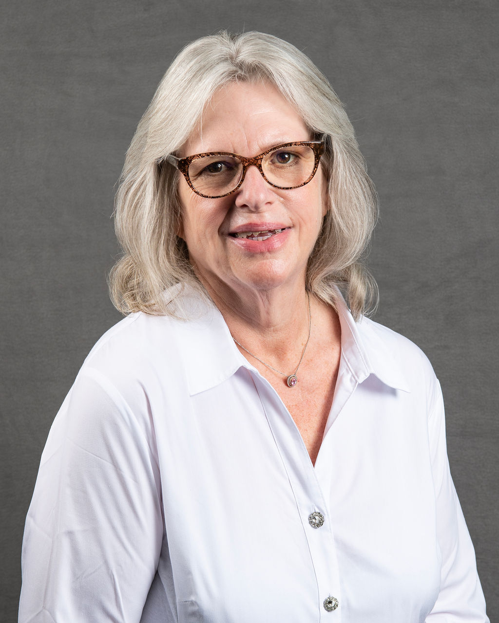a woman with glasses is smiling for the camera