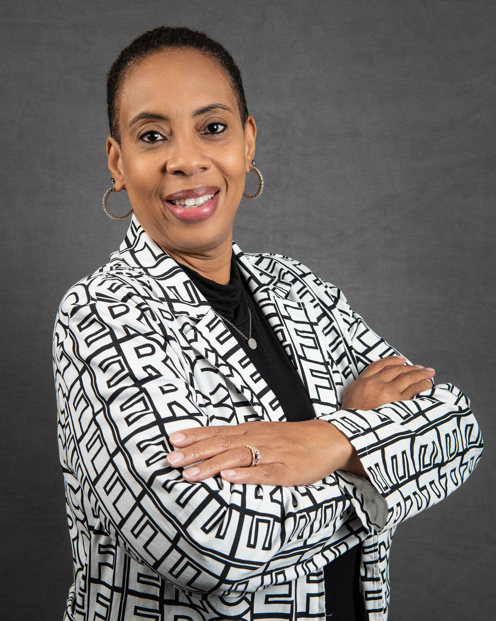 a woman with her arms crossed posing for a photo