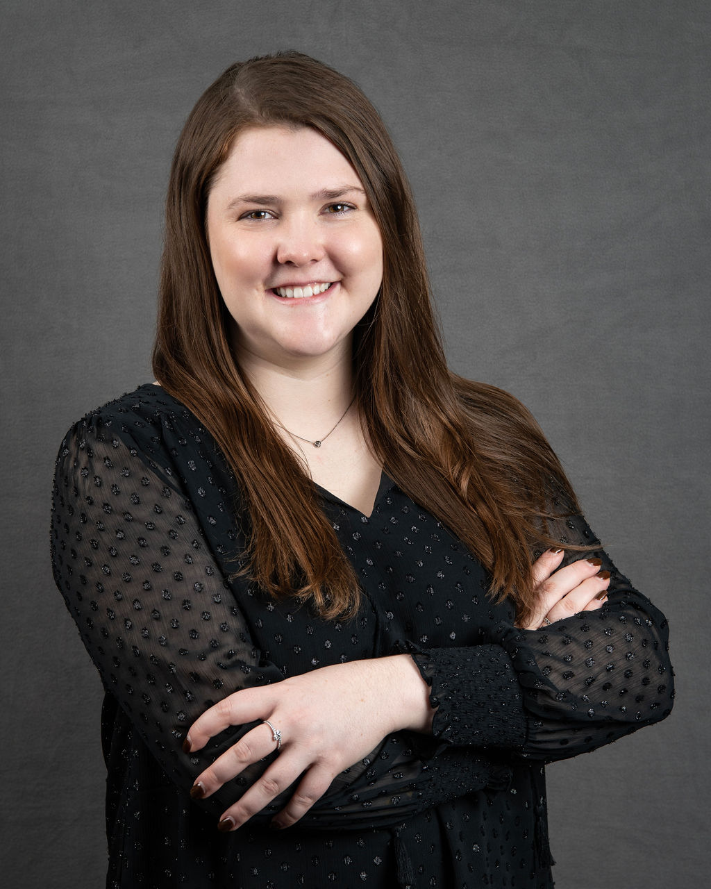 a woman with her arms crossed posing for a photo