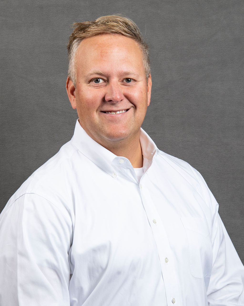 a man in a white shirt is smiling