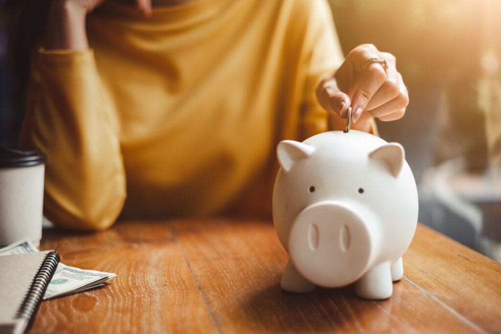 a person putting a coin into a piggy bank