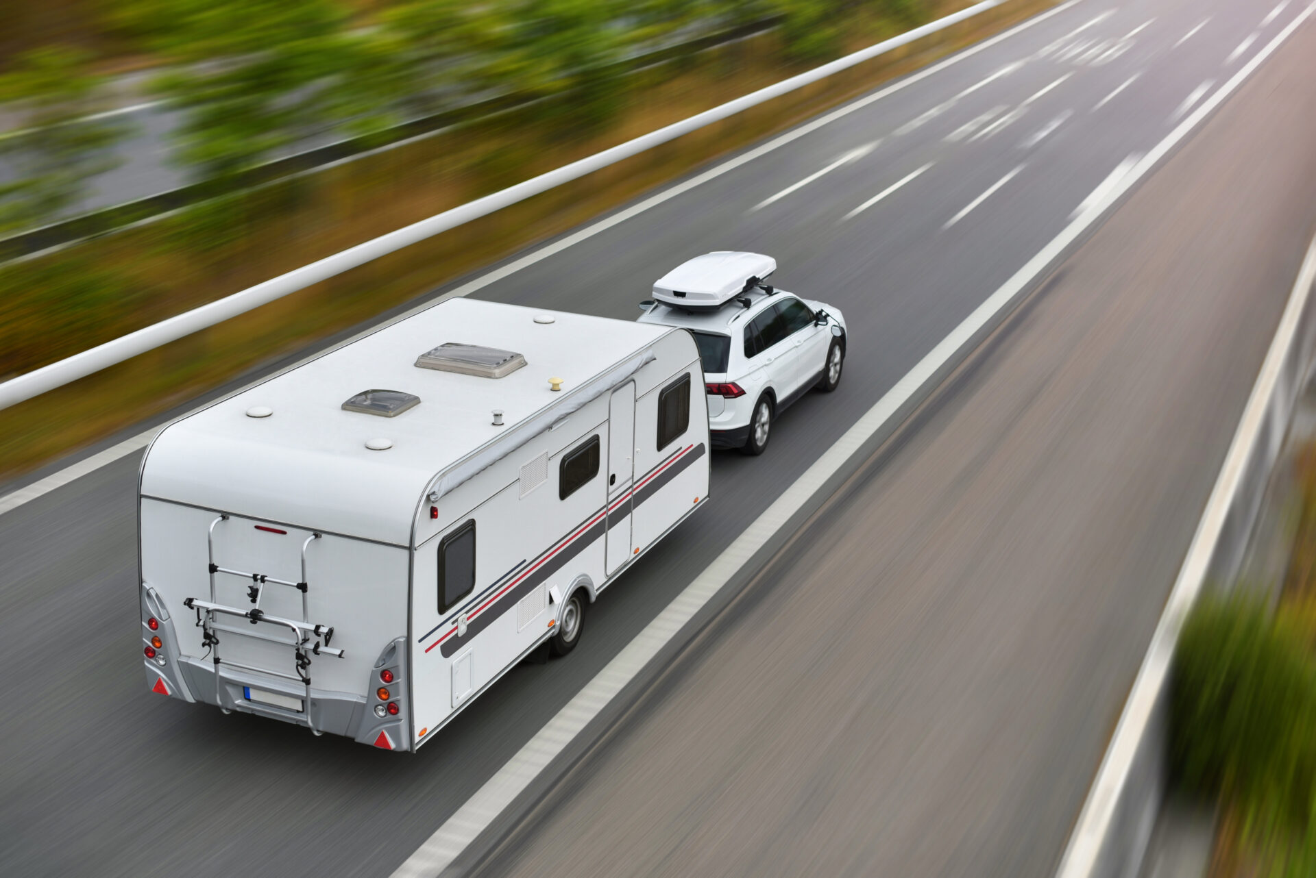 a white van driving down a highway next to a white car