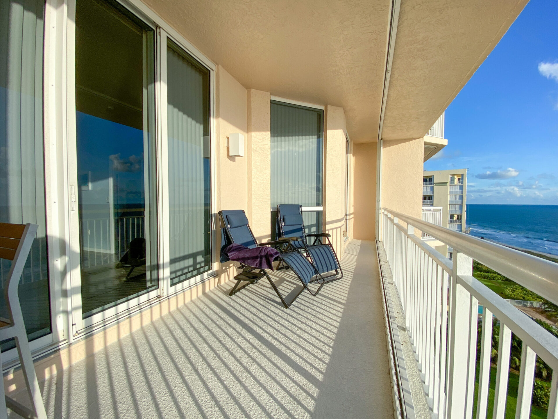 a balcony with chairs and a view of the ocean
