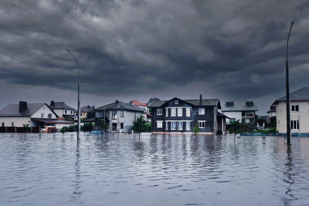 a flooded street with houses in the background