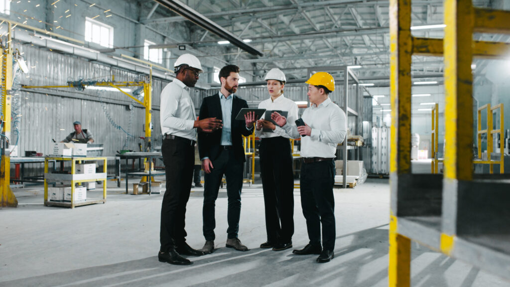 a group of workers standing next to each other in a factory