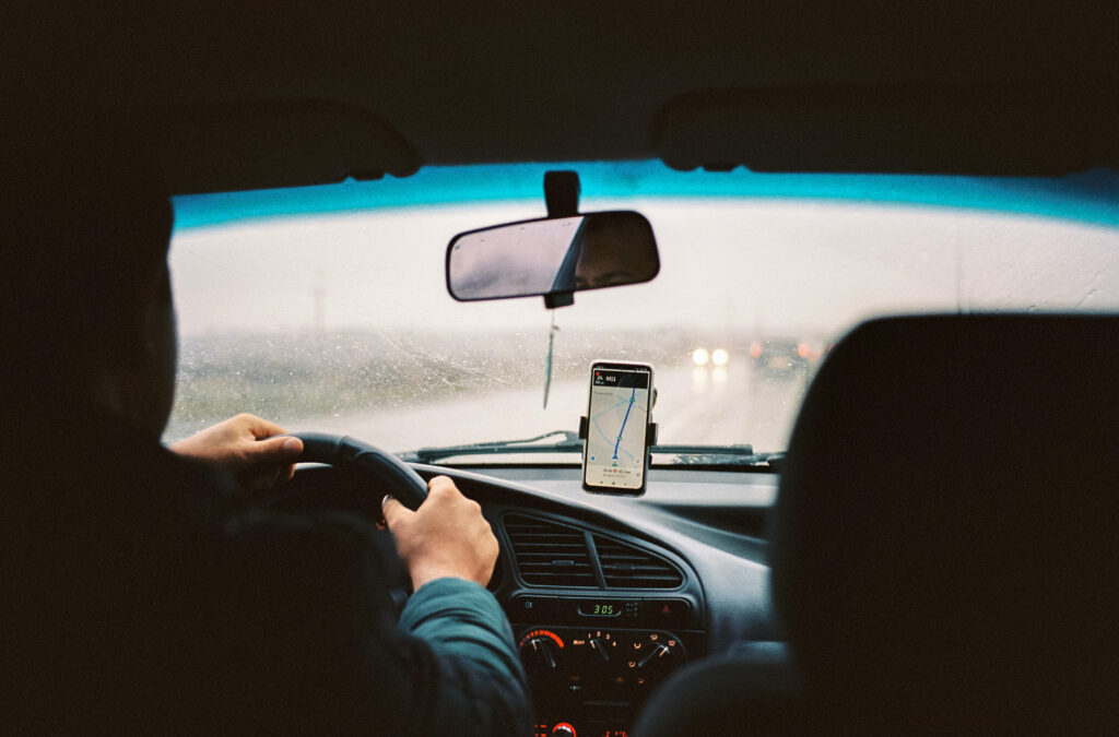 a man driving a car with gps directions on his phone