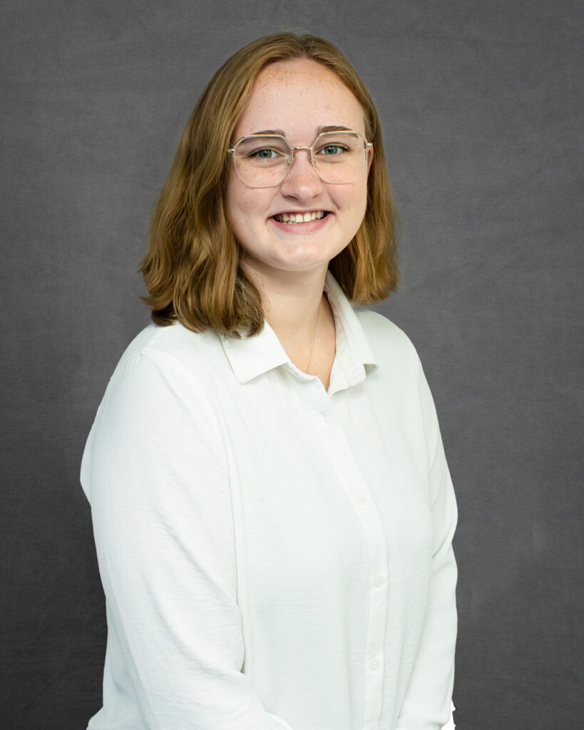 a woman wearing glasses and a white shirt