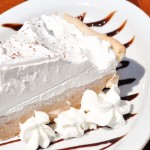 piece of dessert on plate with chocolate drizzles and whip cream