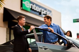 two men standing with rental car in front of building