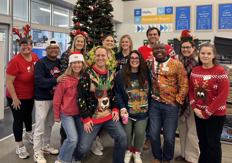 a group of people standing in front of a christmas tree