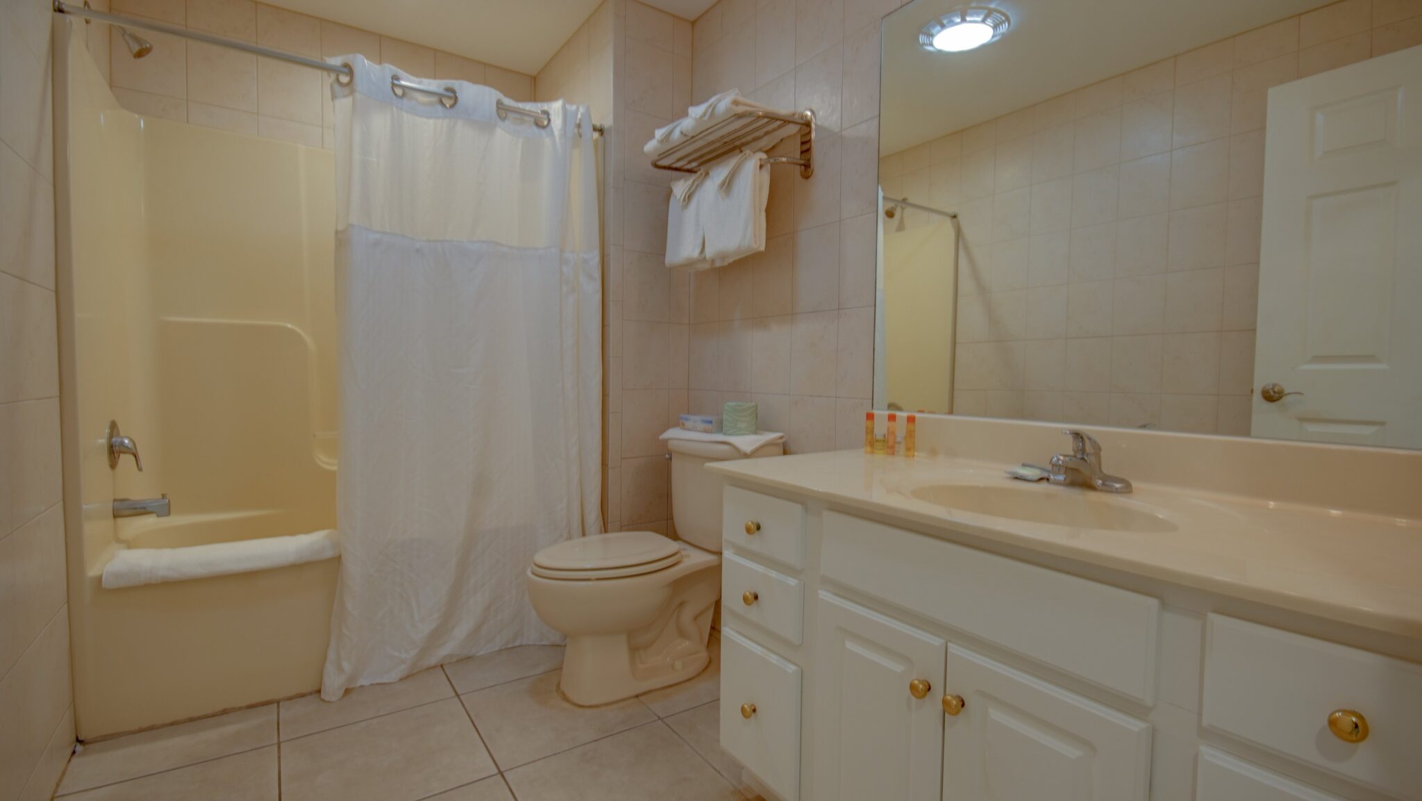 A standard bathroom with a tub, toilet, and vanity