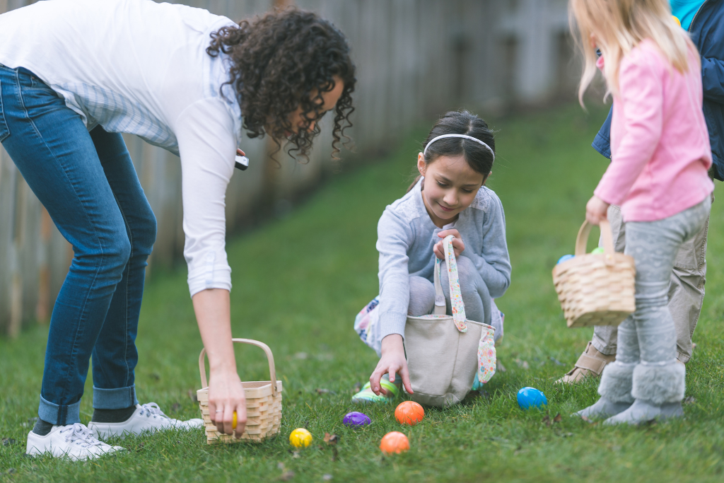 a woman and two children playing with easter eggs
