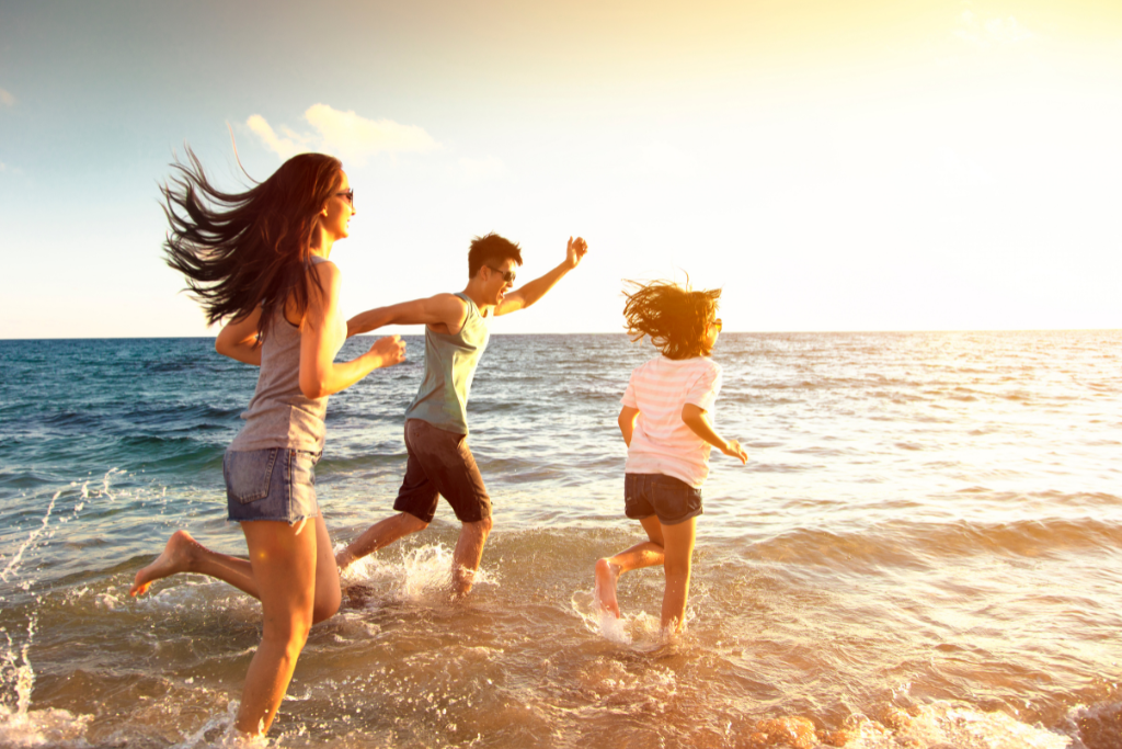 a group of people running on the beach