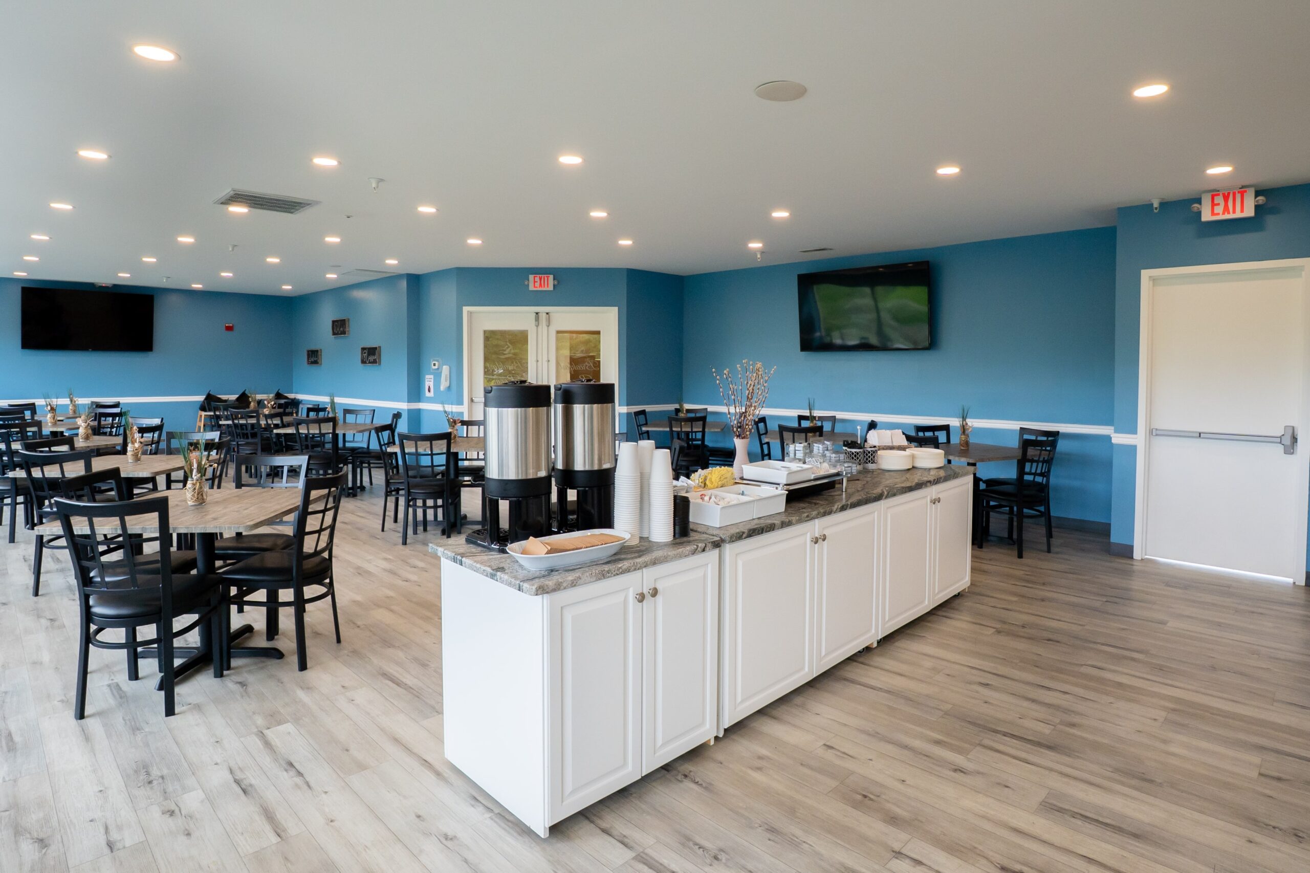 a restaurant with tables, chairs, and televisions