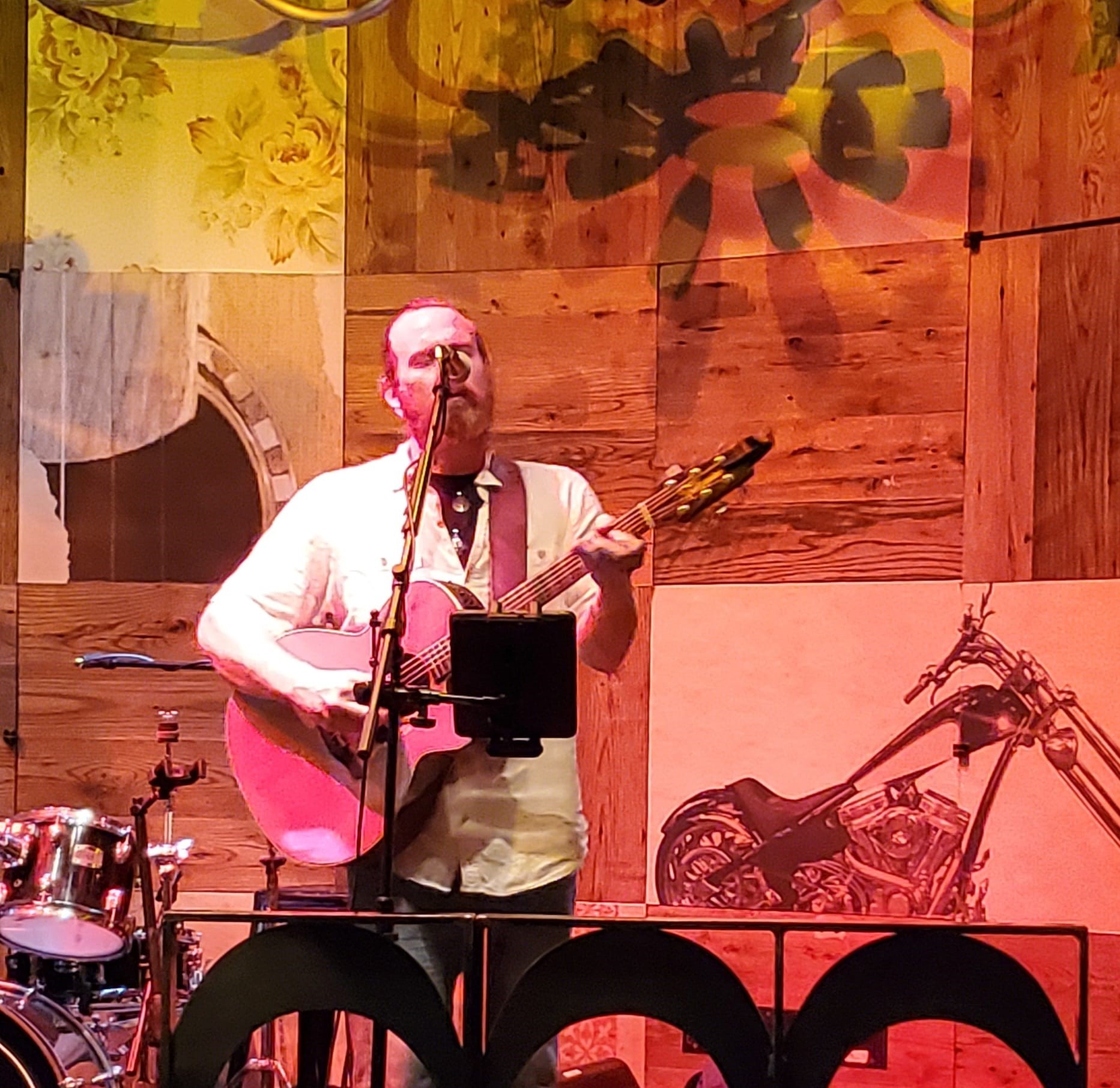 a man standing on a stage with a guitar