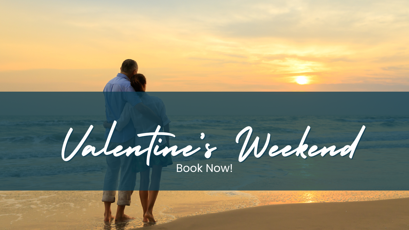 a man and a woman standing on a beach at sunset