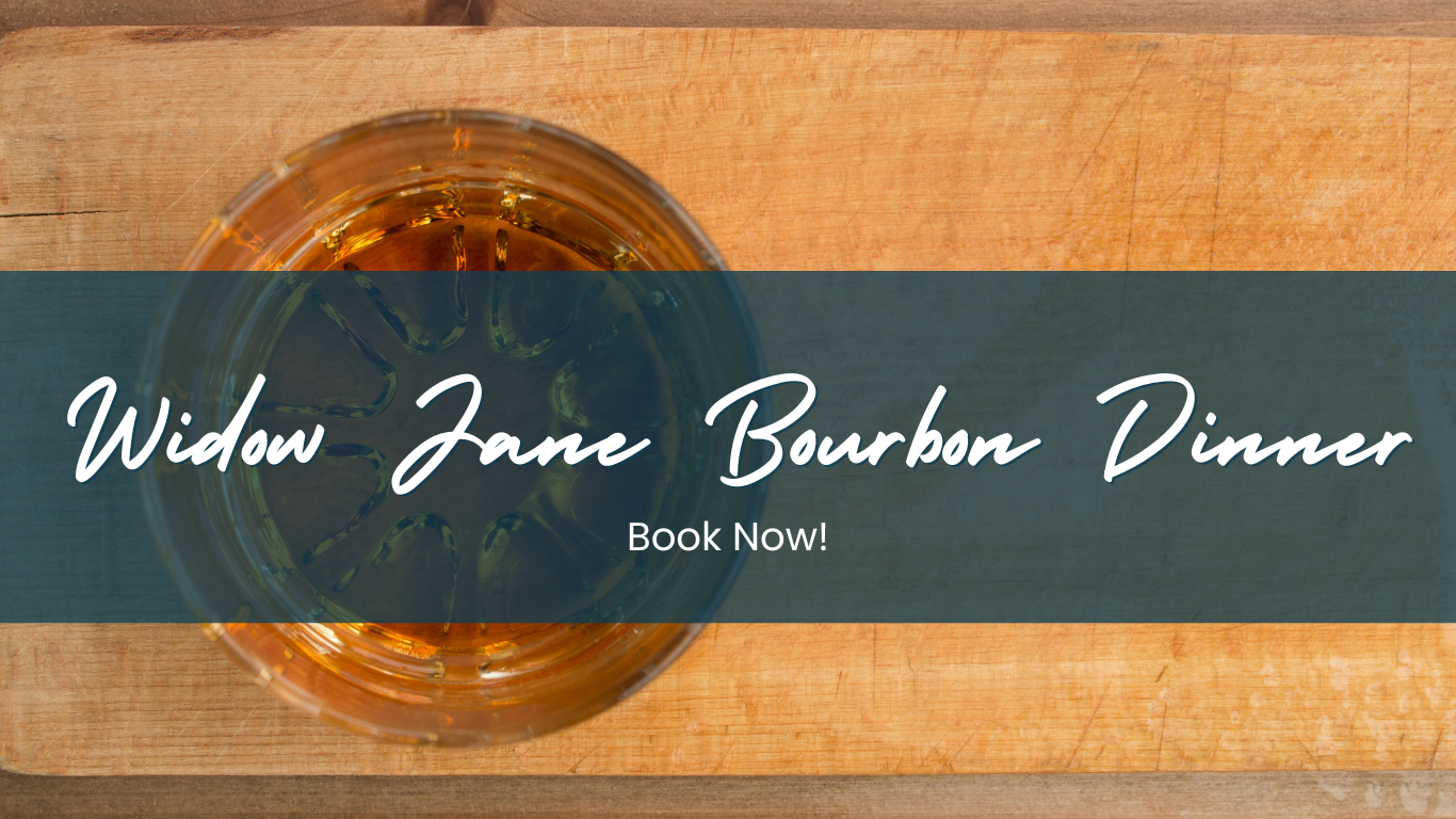 a wooden cutting board with a glass of wine on top of it