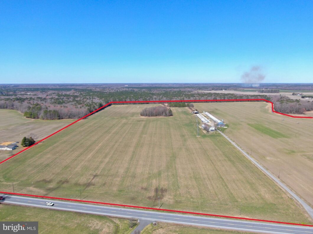 an aerial view of a large field with a road in the foreground
