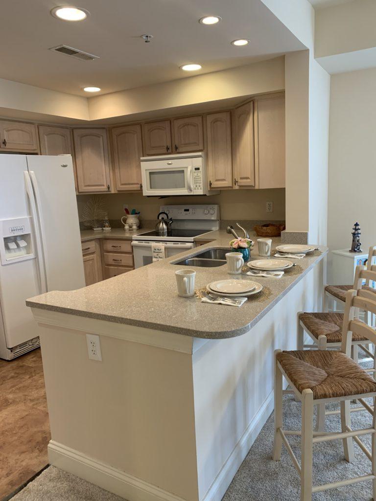 unit full kitchen and dining counter with stools