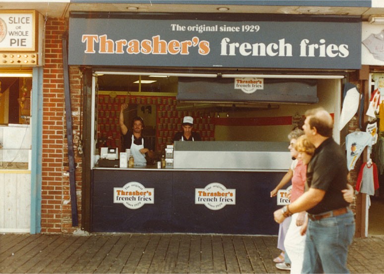 Thrasher's storefront on the boardwalk with employee waving