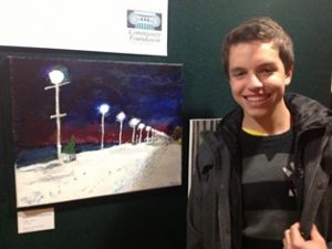 Young boy standing in front of artwork