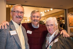 Three people smiling and posing for picture